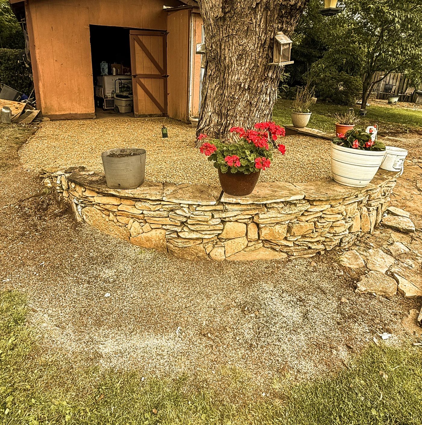 Curved natural stone landscape wall beside a gravel outdoor area
