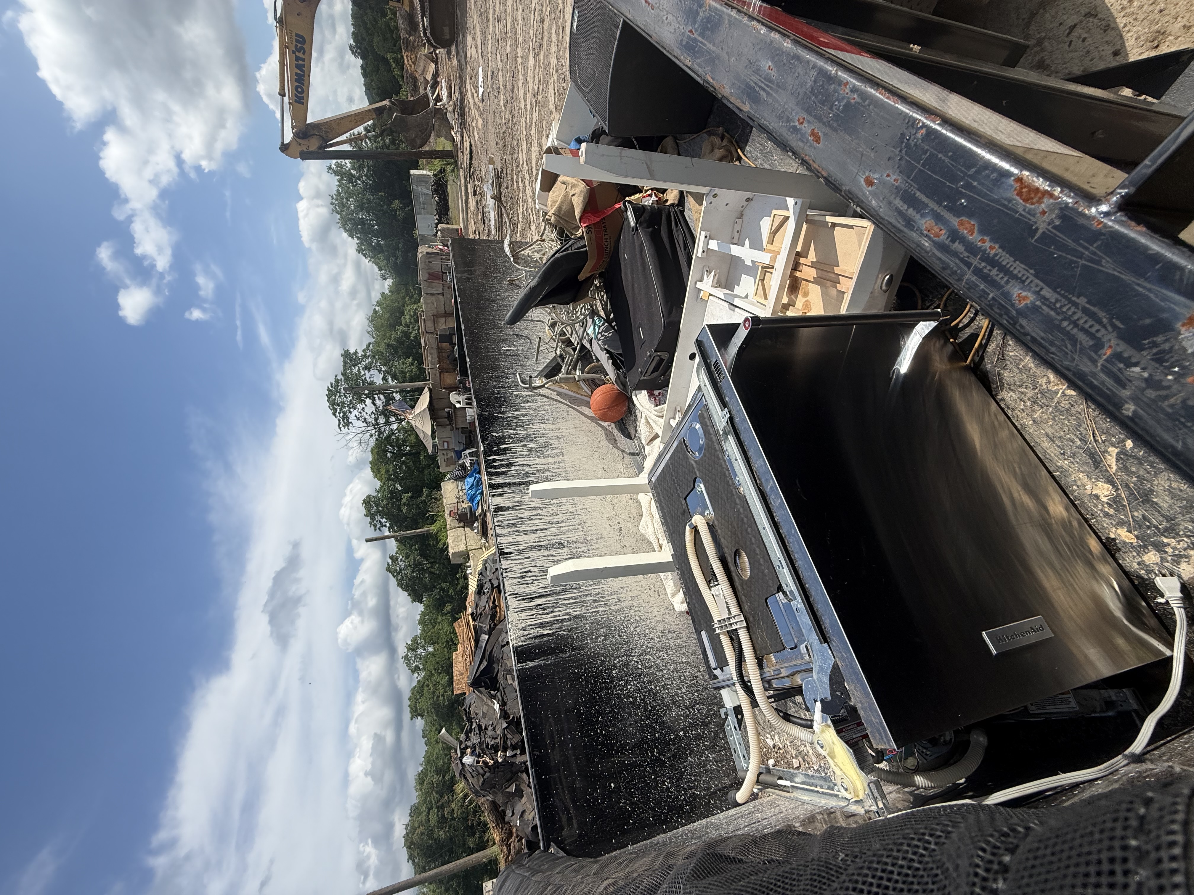 Professional junk removal service showing construction site with large dumpsters and debris removal equipment